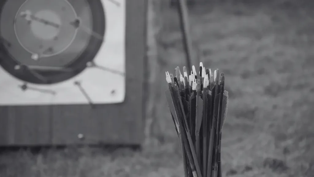 Bundle of arrows in front of an outdoor archery target, representing enrichment activities in home education.