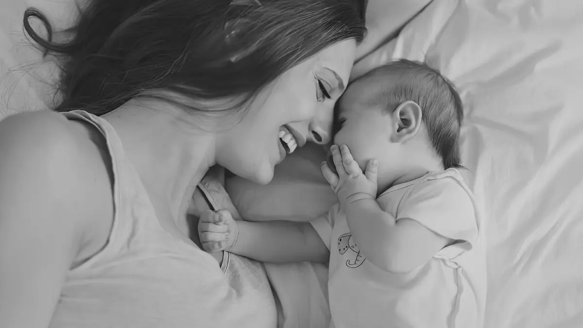Mother lying with her baby, representing the early family connection behind choosing home education.