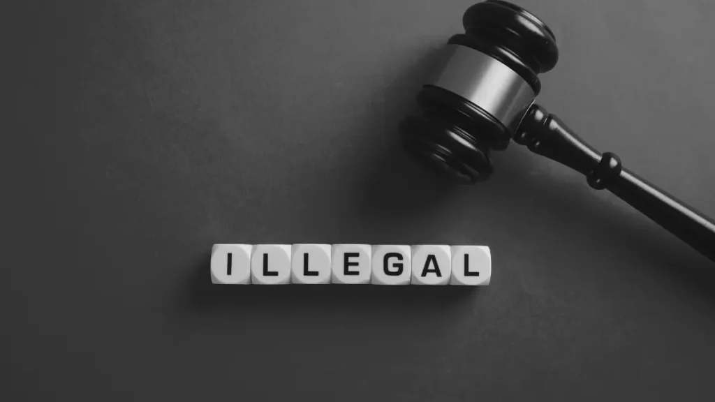 Wooden gavel beside letter blocks spelling illegal, representing the home education myth that educating your child at home is against the law.