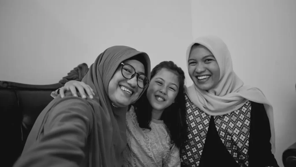 Smiling family taking a photo together, representing community and support in home education.