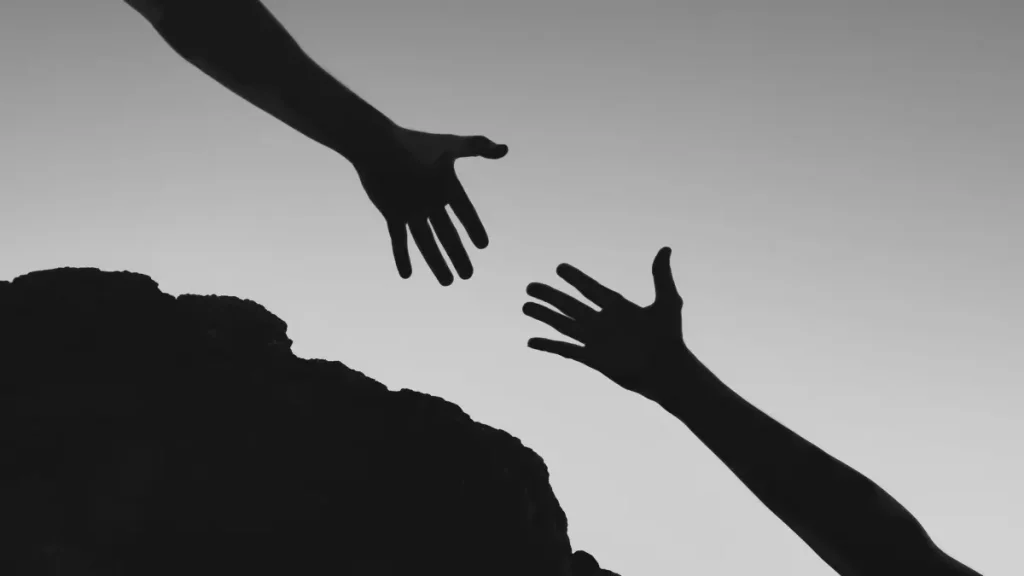 Two hands reaching towards each other, symbolising support for families considering home education.